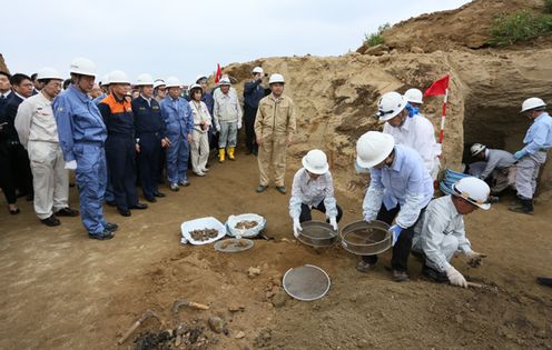 Photograph of the Prime Minister observing the work of collecting the remains of the war dead