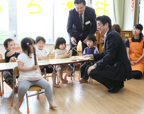 Photograph of the Prime Minister observing children learning about food education