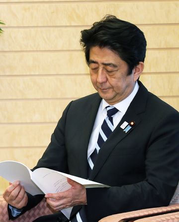 Photograph of the Prime Minister perusing the report