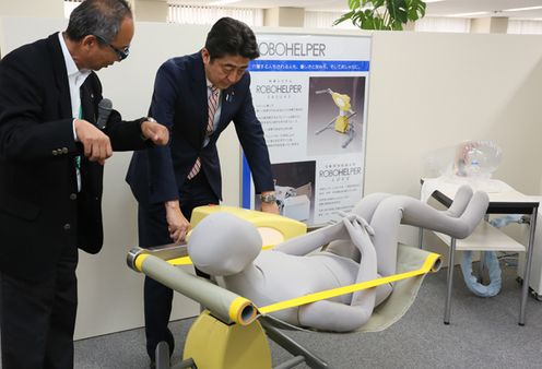 Photograph of the Prime Minister receiving an explanation on a robot for care services at a medical equipment manufacturer