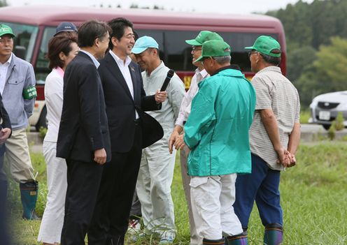 Photograph of the Prime Minister observing a rice paddy where rice cropping has resumed