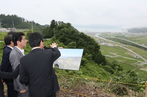 Photograph of the Prime Minister receiving an explanation of the damage from the Mayor of Minamisanriku Town, Mr. Jin Sato