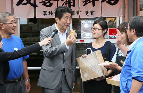 Photograph of the Prime Minister sampling food at the Minamisanriku Sun Sun Shopping Village