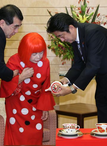 Photograph of Prime Minister Abe being presented with a tea set designed by Ms. Yayoi Kusama