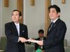 Photograph of Prime Minister Abe receiving a proposal from Chair Masayuki Yamauchi
