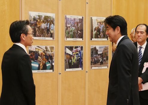 Photograph of the Prime Minister receiving an explanation on the state of activities at the ceremony to commend contributors to the building of safe and reassuring communities (2)