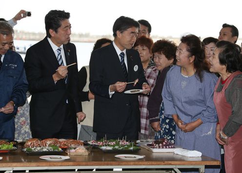 Photograph of the Prime Minister sampling fishery products at the Soma Haragama fishing port