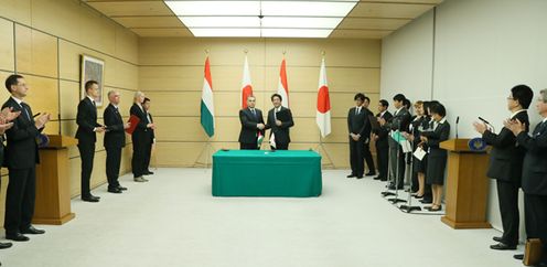 Photograph of the leaders shaking hands after the signing ceremony