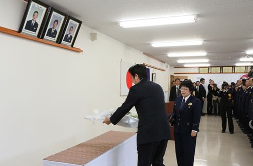 Photograph of the Prime Minister offering flowers to police officers who lost their lives on duty