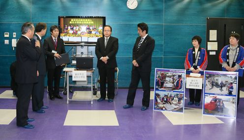 Photograph of the Prime Minister receiving an explanation on the disaster management education provided at elementary and junior high schools