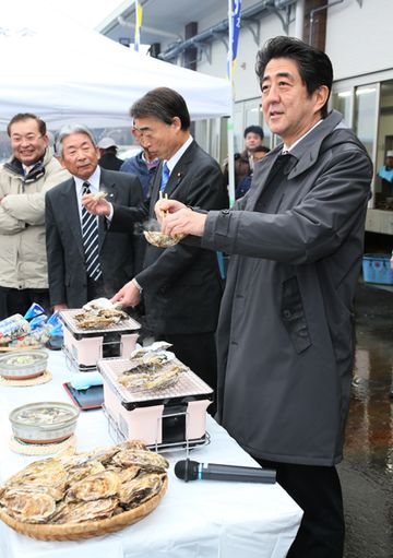 Photograph of the Prime Minister sampling oysters at the joint oyster processing plant (2)