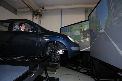 Photograph of the Prime Minister test-driving a driving simulator