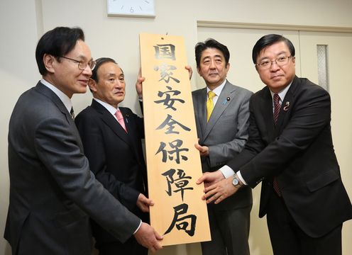 Photograph of the Prime Minister raising a signboard