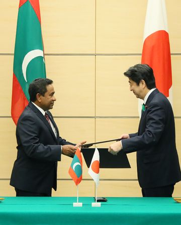 Photograph of the leaders exchanging documents at the signing ceremony