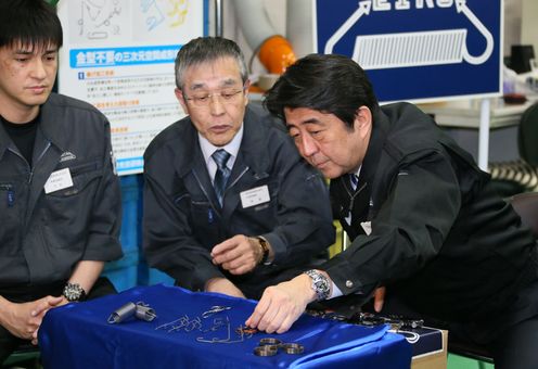 Photograph of the Prime Minister receiving an explanation at a spring plant