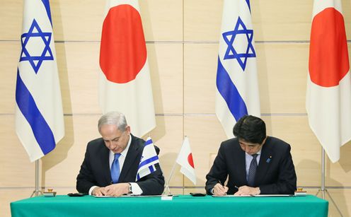 Photograph of the leaders signing documents at the signing ceremony for the joint statement