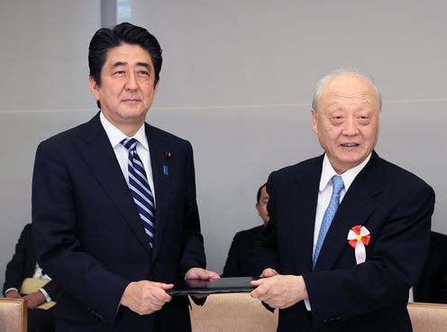 Photograph of the Prime Minister receiving the report from Chairman Shunji Yanai