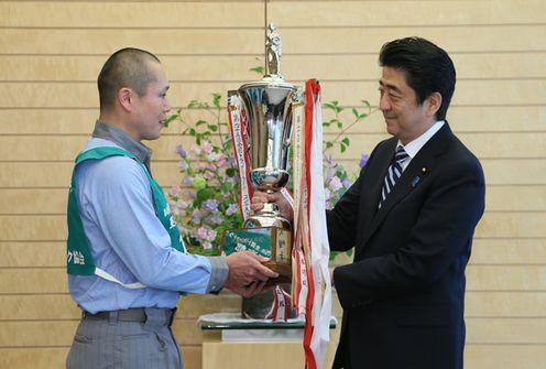 Photograph of the Prime Minister presenting a trophy