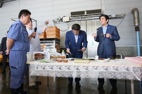 Photograph of the Prime Minister tasting fishery products