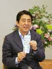 Photograph of the Prime Minister displaying his Tanabata commitment written on a strip of paper