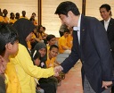 Photograph of the Prime Minister shaking hands with an orphan