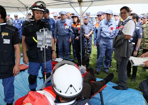 Photograph of the Prime Minister observing the first-aid station drill