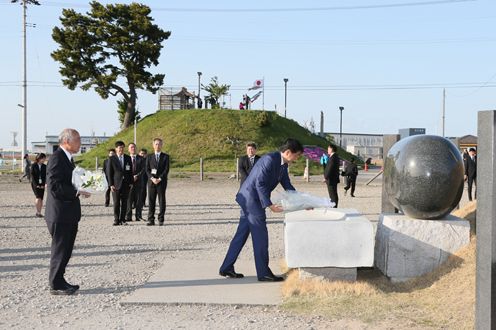 Photograph of the Prime Minister offering flowers in the Yuriage area of Natori City