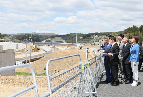 Photograph of the Prime Minister observing the building of the former disaster prevention center from a shopping center in Minamisanriku Town