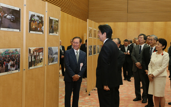 Photograph of the Prime Minister receiving an explanation on the state of activities while viewing a display panel.