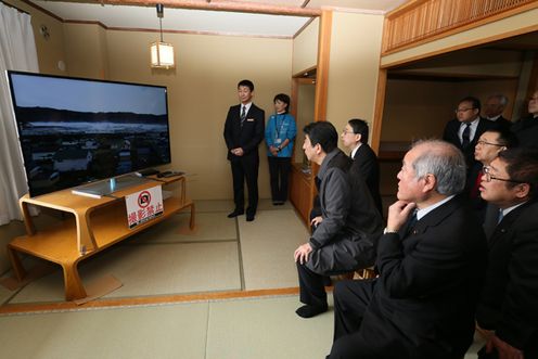 Photograph of the Prime Minister watching a video of the tsunami at the site where the damages from the Great East Japan Earthquake have been preserved