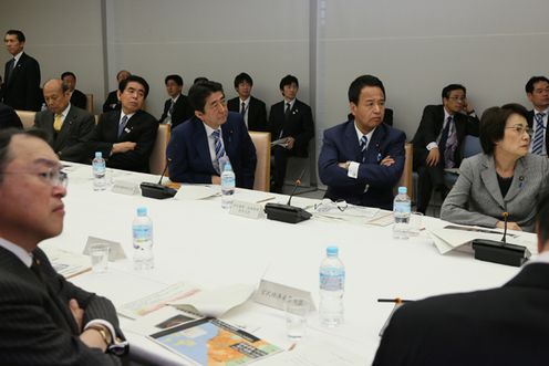 Photograph of the Prime Minister listening to an expert’s explanation