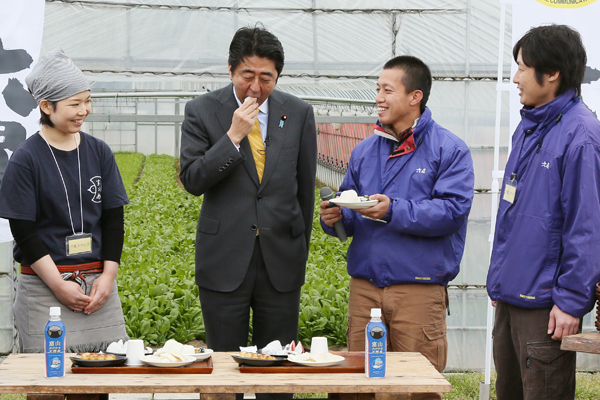 Photograph of the Prime Minister tasting processed products made by an agricultural corporation