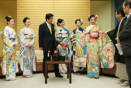 Photograph of the Prime Minister receiving an explanation of a kimono