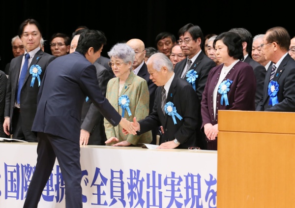 Photograph of Prime Minister Abe shaking hands with members of the families of abductees