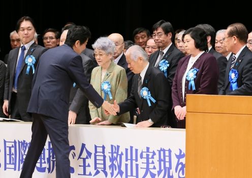 Photograph of Prime Minister Abe shaking hands with members of the families of abductees