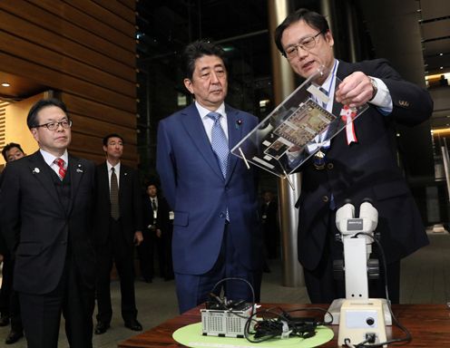 Photograph of the Prime Minister observing the product sample exhibition (1)