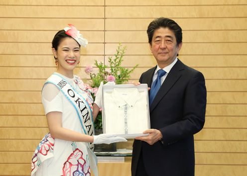 Photograph of the Prime Minister being presented with a kariyushi shirt