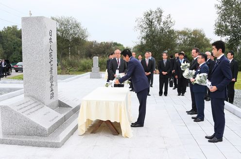 Photograph of the Prime Minister offering flowers at a memorial monument for Japanese Detainees
