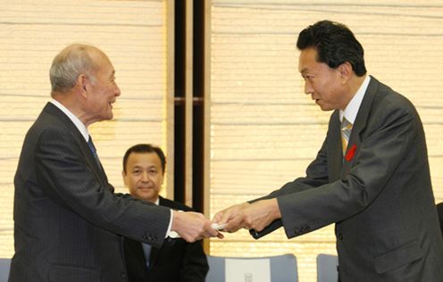 Photograph of the Prime Minister handing a consultative document to Minister of Finance Hirohisa Fujii