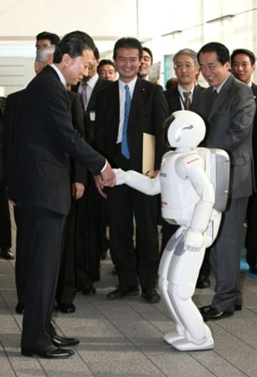 Photograph of the Prime Minister shaking hands with a robot at the demonstration