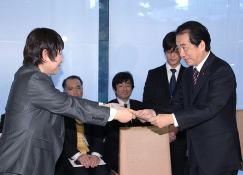 Photograph of the Prime Minister receiving the project from Minister of State for Social Affairs and Gender Equality Tomiko Okazaki