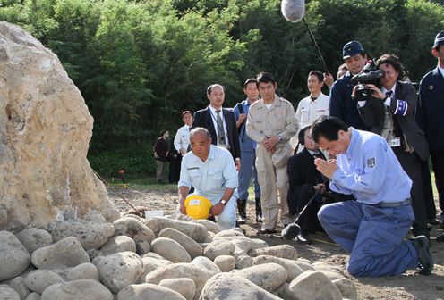 Photograph of the Prime Minister joining his hands in prayer in front of the remains of the war dead