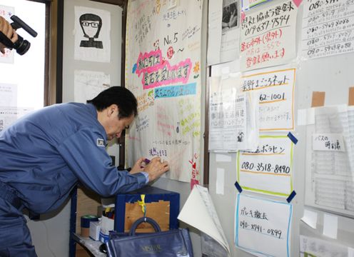 Photograph of the Prime Minister writing a message at the Volunteer Center