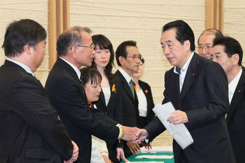 Photograph of the Prime Minister shaking hands with the plaintiffs in a hepatitis B suit