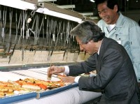 Photograph of Prime Minister experiencing stage curtain weaving with a loom