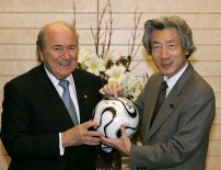 Photograph of President Blatter and Prime Minister Koizumi taking a commemorative photograph holding the soccer ball with their autographs