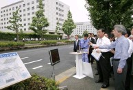 Photograph of Prime Minister receiving an explanation on the water-retentive pavement device and sprinklers
