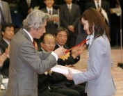 Photograph of Prime Minister Koizumi presenting a commemorative gift to Ms. Shizuka Arakawa, a gold medalist at the Winter Olympics in Turin
