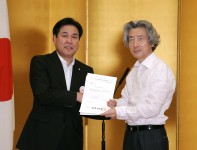 Photograph of Prime Minister holding the certification with representative of plans for special zones
