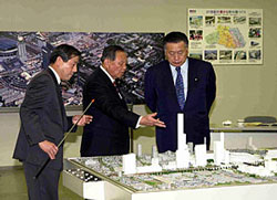 Seeing the miniature of the Saitama New Urban Center in front of him, Prime Minister Mori listens to the explanation of Governor Tsuchiya of the Saitama Prefecture